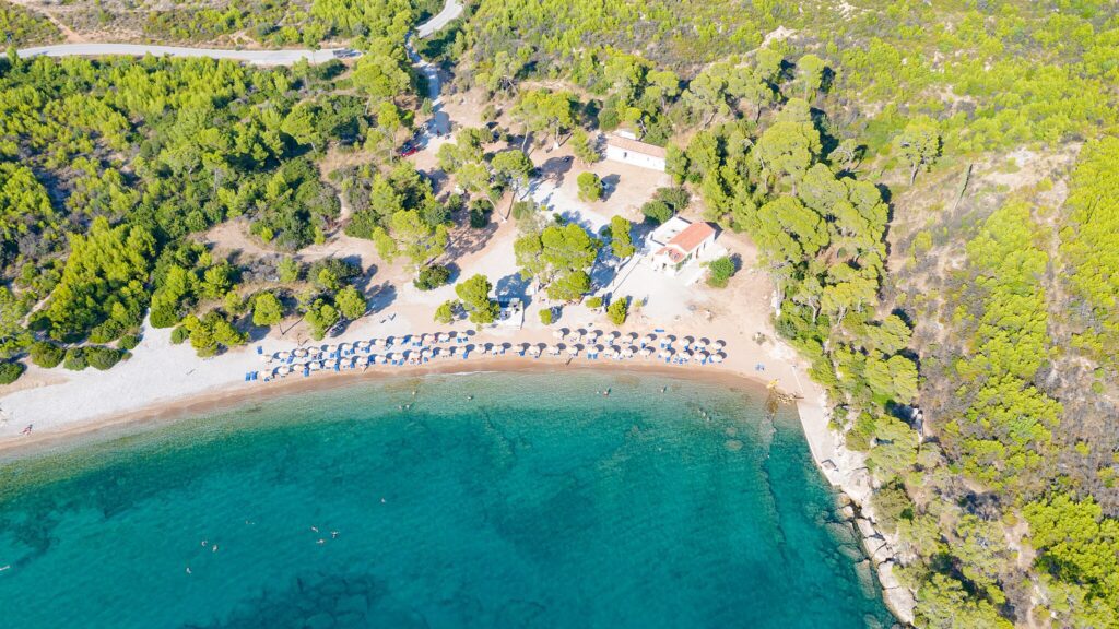 This image has an empty alt attribute; its file name is 2048px-Aerial_view_of_Agia_Paraskevi_Beach_on_Spetses_Greece_48760200611-1024x576.jpg